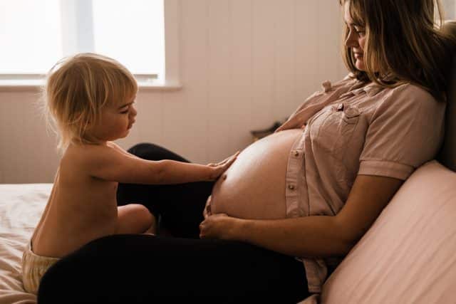 Mother with a pregnant belly with toddler